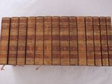 six vieux livres empilés sur une surface blanche