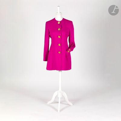 un manteau rose posé sur un pied de mannequin, devant un fond blanc