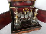 bottles and glasses in a wooden box on a white surface