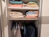 une armoire pleine de vêtements et des vêtements suspendus aux étagères