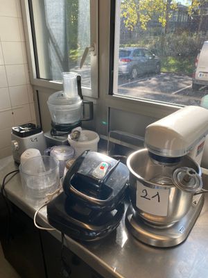 a kitchen counter with a mixer, blender, and other items on it