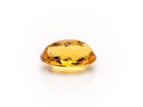 a yellow sapphire stone on a white background