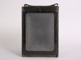 a close up of an old camera on a white surface