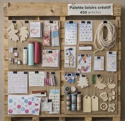une palette en bois sur laquelle sont posés de nombreux articles de loisirs créatifs