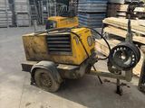 a yellow machine that is sitting in the middle of a pile of wood