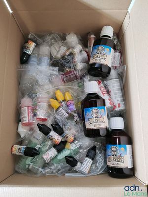 une boîte en carton remplie de bouteilles d'alcool et d'autres objets