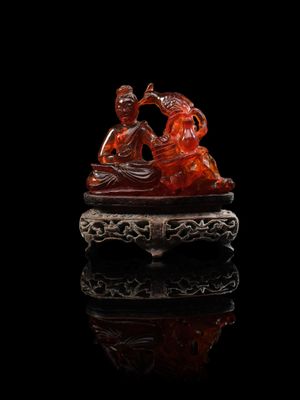 une figurine en jade rouge sculptée représentant un homme et une femme sur un bateau