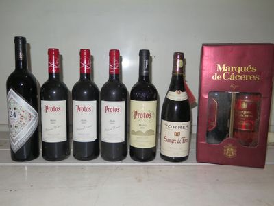Plusieurs bouteilles de vin sont alignées sur un comptoir, à côté d'une caisse de vin