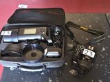 a suitcase with a camera and other items in it on the floor