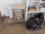 a trash bag sitting on the floor next to a book shelf
