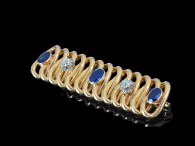 gros plan d'une bague en or avec saphirs et diamants