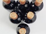 six bottles of wine are arranged in a circle on a white surface