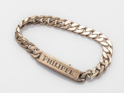 a close up of a gold bracelet with a nameplate on it