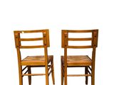 two wooden chairs sitting next to each other on a white surface