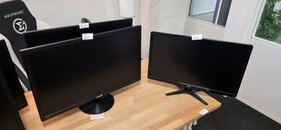 trois écrans d'ordinateur posés sur un bureau dans une pièce