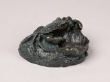 an image of a statue of a frog sitting on top of a rock