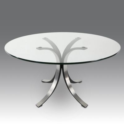 une table ronde en verre avec des pieds en métal et un plateau en verre