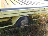 a flatbed truck with a flat bed sitting in the grass
