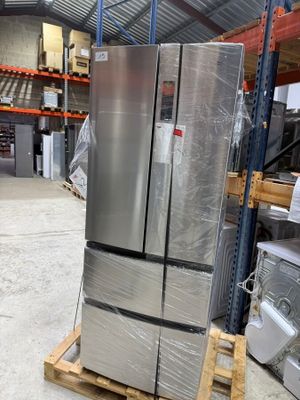a silver refrigerator sitting on a pallet in a warehouse