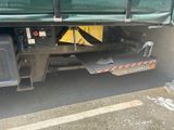 a green truck with a yellow tarp on the back of it
