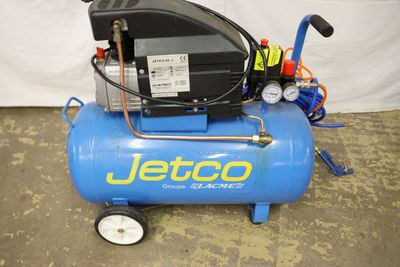 an image of a blue air compressor sitting on top of a cement floor