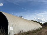 a large metal structure sitting in the middle of a field