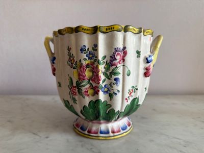 un vase blanc avec des fleurs posé sur une table