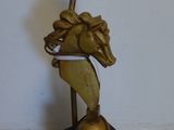 une statue de cheval posée sur un socle muni d'un bougeoir