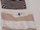 two sweaters and a purse sitting on a table with a zebra print bag