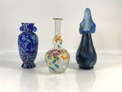 three different colored vases sitting next to each other on a white surface