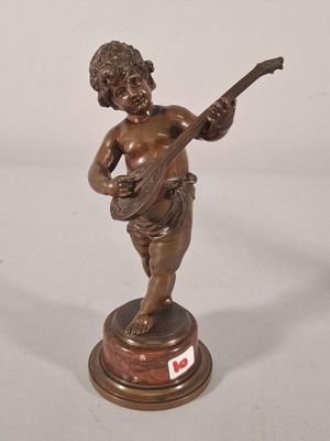 bronze figurine of a boy playing a guitar on a pedestal