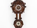une vieille horloge murale en bois avec un pendule, accrochée au mur