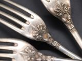 three forks that are sitting on a black table