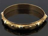 un bracelet rigide ancien en or, orné d'un motif gravé