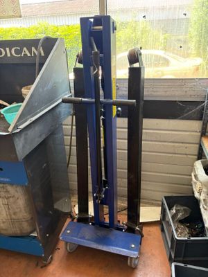 a blue hand truck that is sitting in front of a window