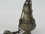a metal object with a chain around it on a white surface