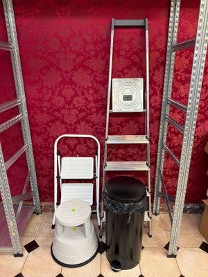 des toilettes et une échelle dans une pièce aux murs rouges