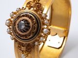Gros plan sur une bague en or ornée d'une pierre noire