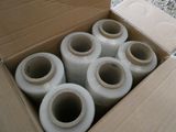 six rouleaux de ruban adhésif en plastique dans une boîte posée par terre