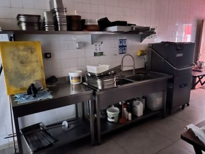 une cuisine équipée d'un évier, d'une cuisinière et d'autres éléments posés sur le plan de travail