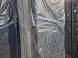 de nombreux meubles emballés dans du plastique dans un entrepôt