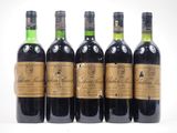 six bottles of wine are lined up on a white surface