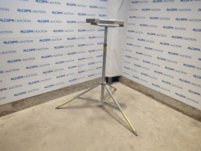 On voit l'image d'un microphone posé sur un trépied devant un mur.