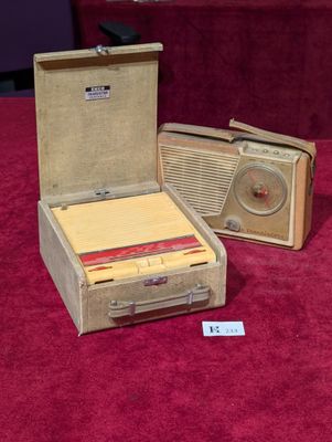 deux valises et une radio posées sur un tapis rouge