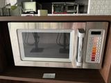 un micro-ondes posé sur une étagère dans une cuisine