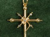 gold plated cross pendant with clear crystal stones on green velvet