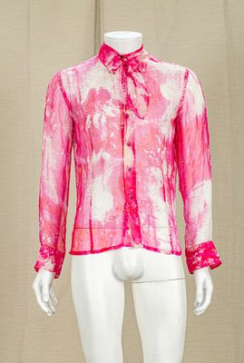 Le mannequin porte une chemise rose avec une cravate.