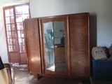 une armoire en bois surmontée d'un miroir, placée dans un coin de la pièce