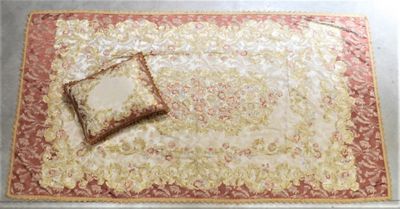 un tapis rouge et doré sur lequel est posé un coussin