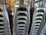 de nombreuses chaises empilées les unes sur les autres dans un magasin